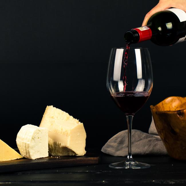 7. proeverij photo-of-person-pouring-wine-into-glass-besides-some-cheese-1545529.jpg